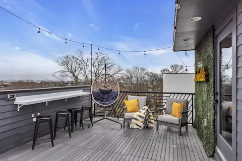 an outdoor sitting area with furniture and wooden floor