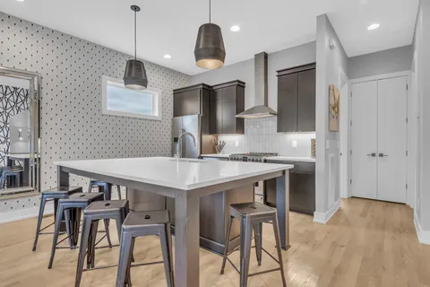 a kitchen with stainless steel appliances granite countertop a kitchen island a stove a table and chairs in it