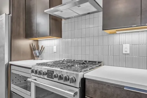 a stove top oven sitting inside of a kitchen