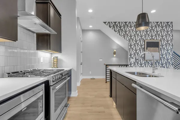 a kitchen with granite countertop a sink stove and cabinets