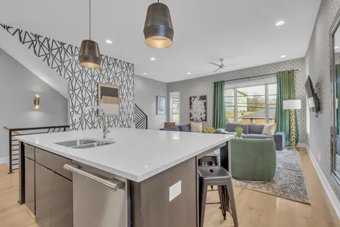 a kitchen with a table a refrigerator a sink and a stove