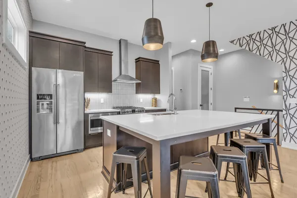 a kitchen with stainless steel appliances granite countertop a sink a stove a refrigerator and a stove
