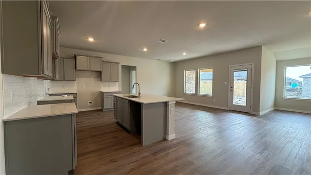 a view of kitchen with granite countertop stainless steel appliances refrigerator sink and cabinets