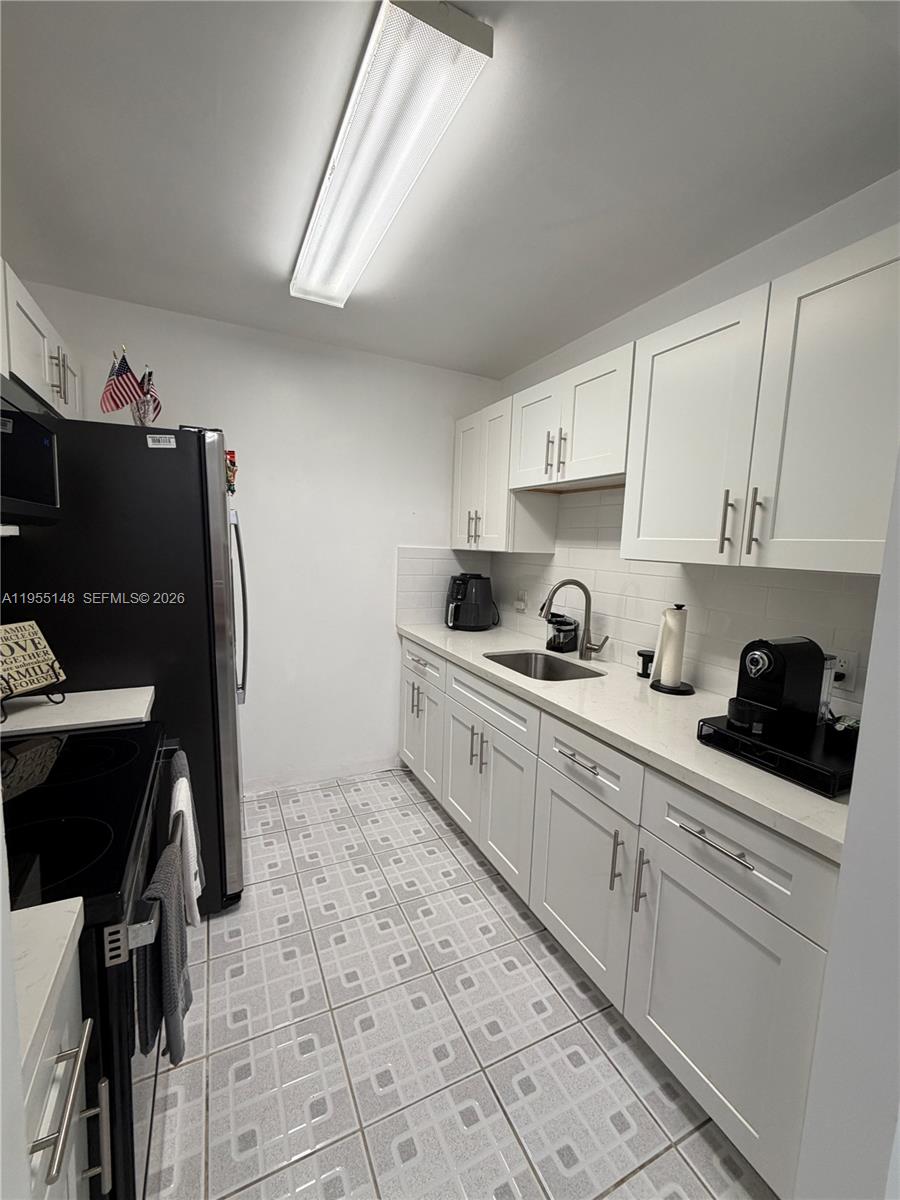 200 Southwest 132nd Way, Unit 109L Pembroke Pines, FL 33027 - Photo 3 of 18 a kitchen with stainless steel appliances a sink stove and cabinets