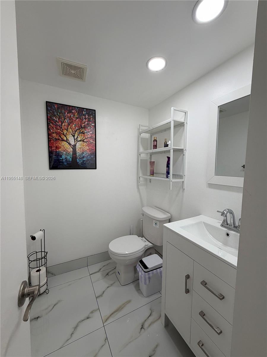 200 Southwest 132nd Way, Unit 109L Pembroke Pines, FL 33027 - Photo 6 of 18 a bathroom with a toilet sink and mirror