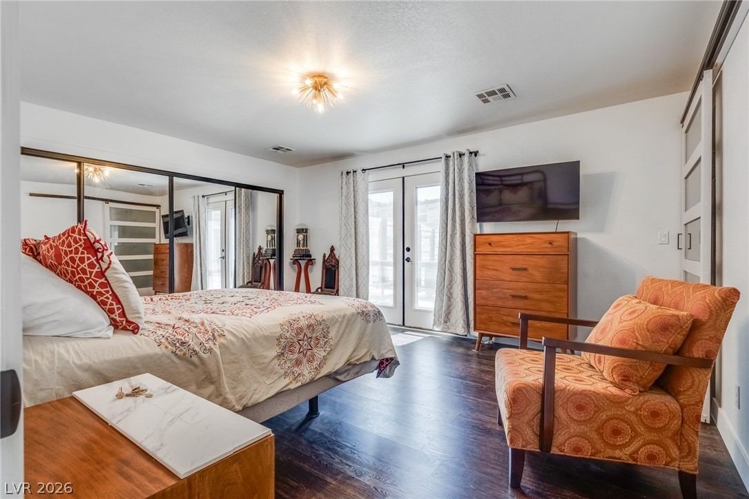 524 Swallow Cove Boulder City, NV 89005 - Photo 22 of 58 Rich hardwood floors complement the neutral tones in this inviting bedroom with French doors leading to outdoor relaxation.