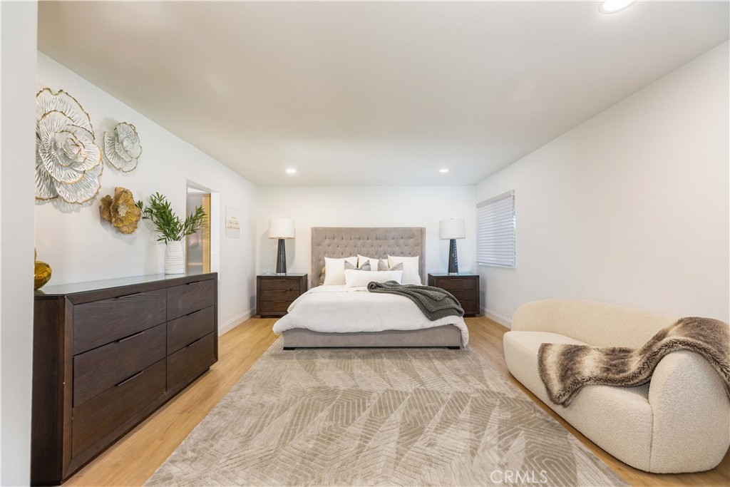 1117 Dennis Drive Costa Mesa, CA 92626 - Photo 19 of 44 a spacious bedroom with a bed and painting on the wall