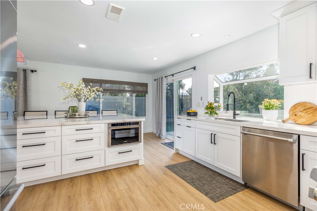 1117 Dennis Drive Costa Mesa, CA 92626 - Photo 4 of 44 a large kitchen with stainless steel appliances a large counter top a stove and a sink