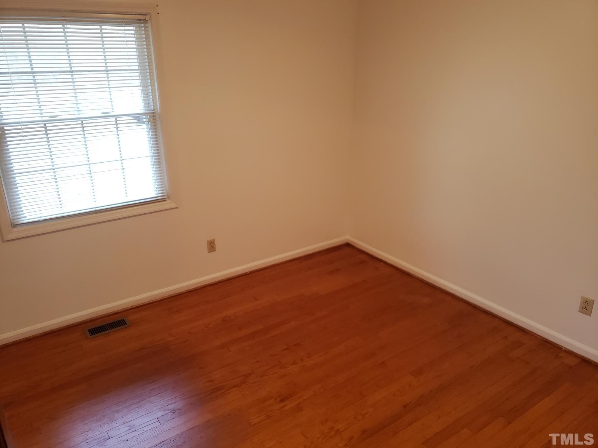 212 Longview Drive Smithfield, NC 27577 - Photo 10 of 21 an empty room with wooden floor and windows