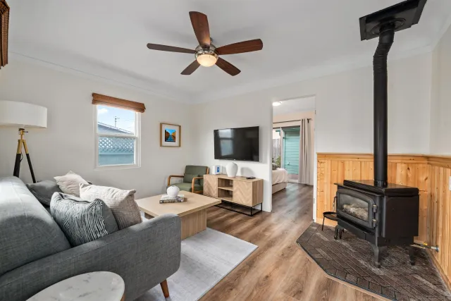 a living room with furniture a ceiling fan and a flat screen tv