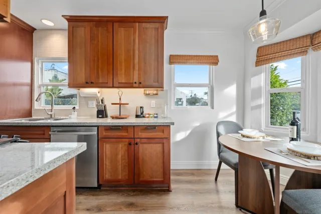 a kitchen with stainless steel appliances granite countertop wooden cabinets a sink and a stove