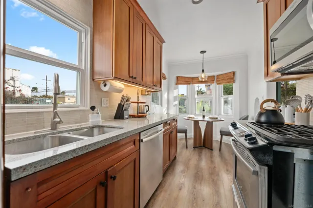 a kitchen with stainless steel appliances a sink stove and cabinets