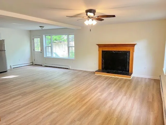 wooden floor fireplace and windows in an empty room