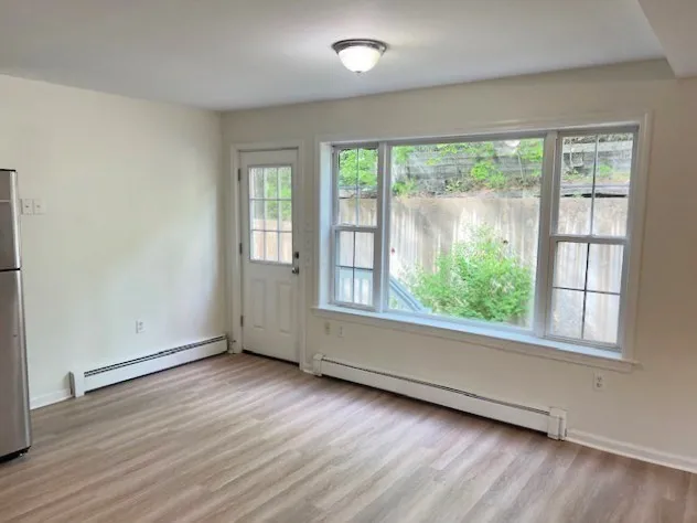 an empty room with wooden floor and windows