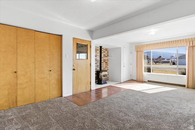 217 East 400 South Spring City, UT 84662 - Photo 6 of 71 Entrance foyer with carpet, a wood stove, and a mountain view