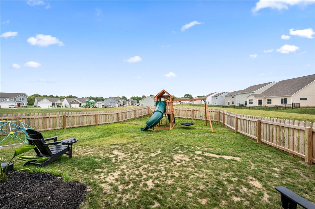 3011 Falls Road Clayton, OH 45315 - Photo 59 of 66 A fully fenced backyard, perfect for play, featuring a swingset with a slide and ample green space.