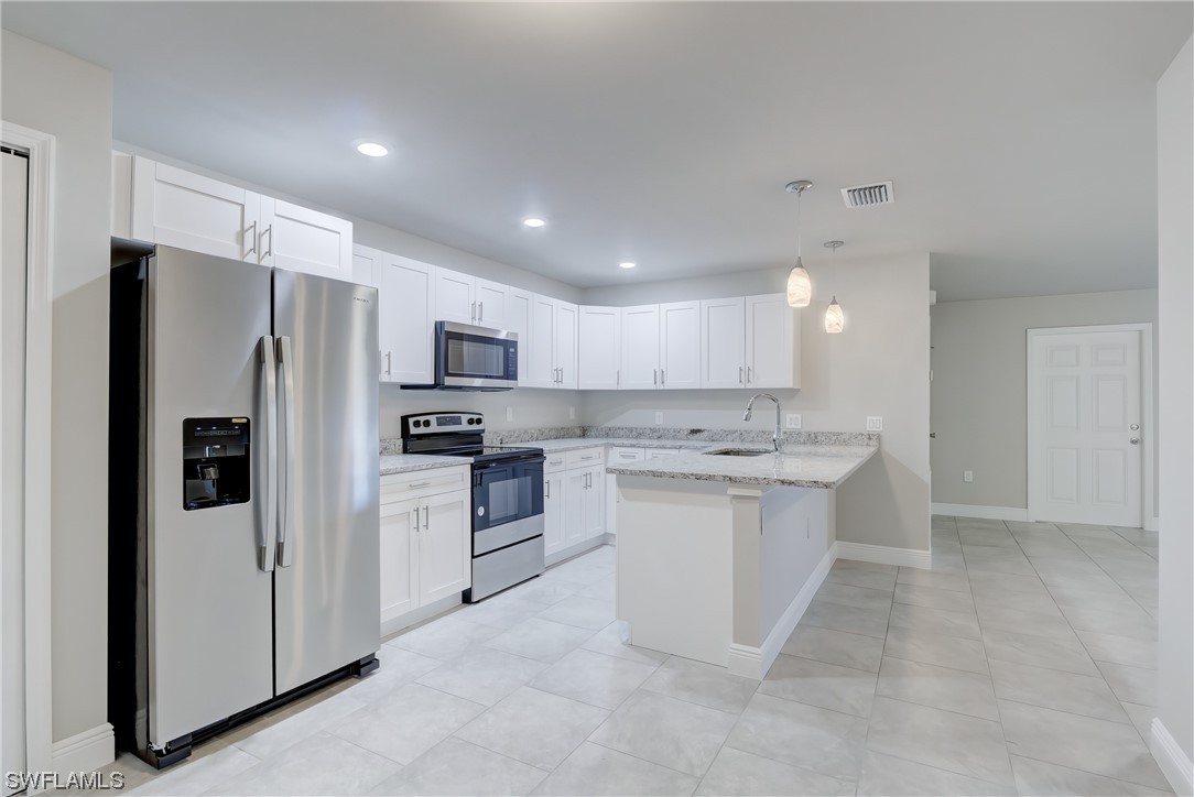3215 46th Street West Lehigh Acres, FL 33971 - Photo 12 of 50 a kitchen with a sink stainless steel appliances and cabinets