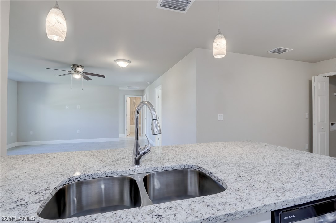 3215 46th Street West Lehigh Acres, FL 33971 - Photo 14 of 50 a kitchen with a sink a counter space and a refrigerator