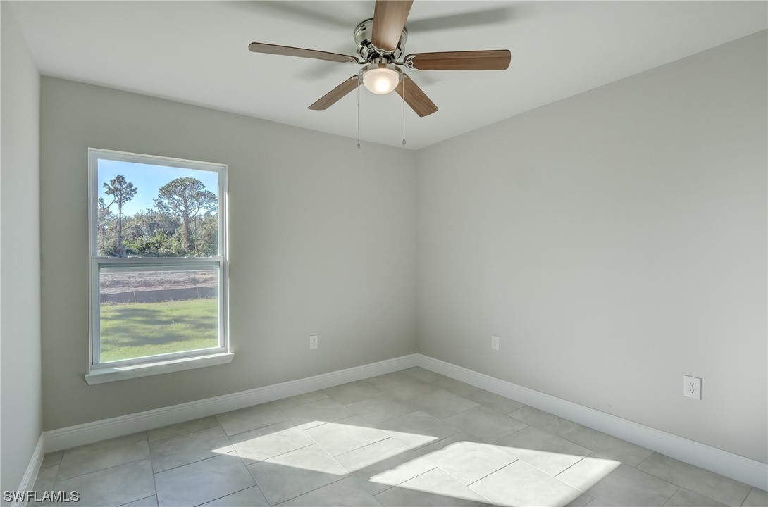 3215 46th Street West Lehigh Acres, FL 33971 - Photo 17 of 50 an empty room with a window and a fan
