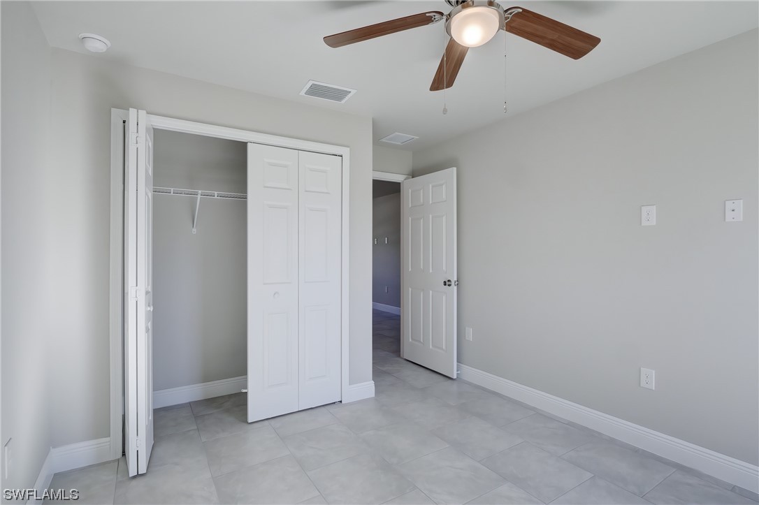 3215 46th Street West Lehigh Acres, FL 33971 - Photo 19 of 50 an empty room with closet and a chandelier fan