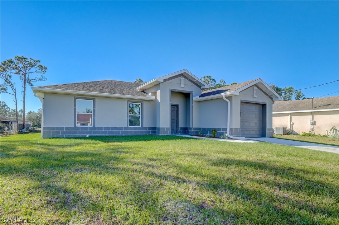 3215 46th Street West Lehigh Acres, FL 33971 - Photo 2 of 50 a front view of a house with garden