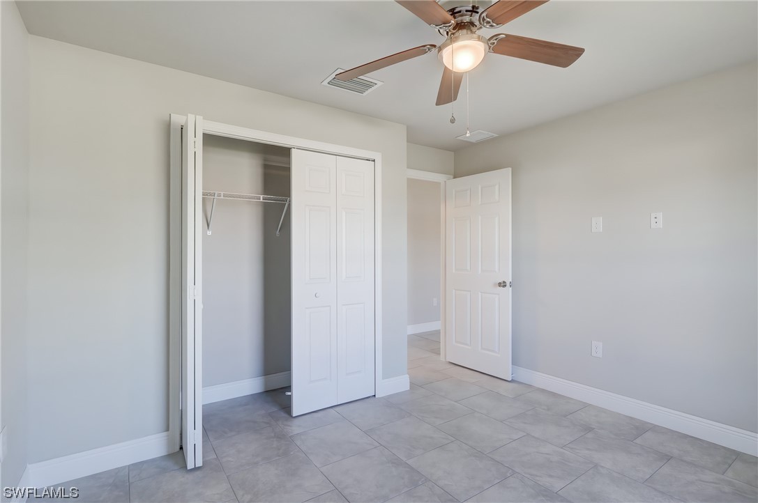 3215 46th Street West Lehigh Acres, FL 33971 - Photo 22 of 50 an empty room with chandelier fan and ceiling fan