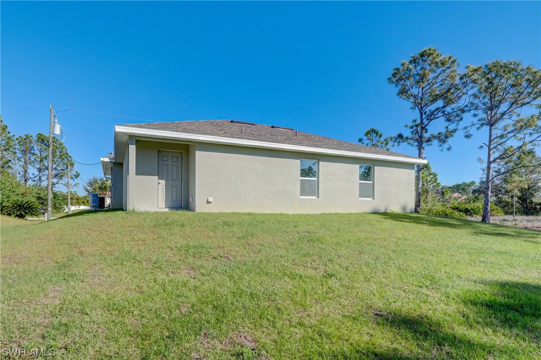 3215 46th Street West Lehigh Acres, FL 33971 - Photo 30 of 50 a front view of house with yard and trees