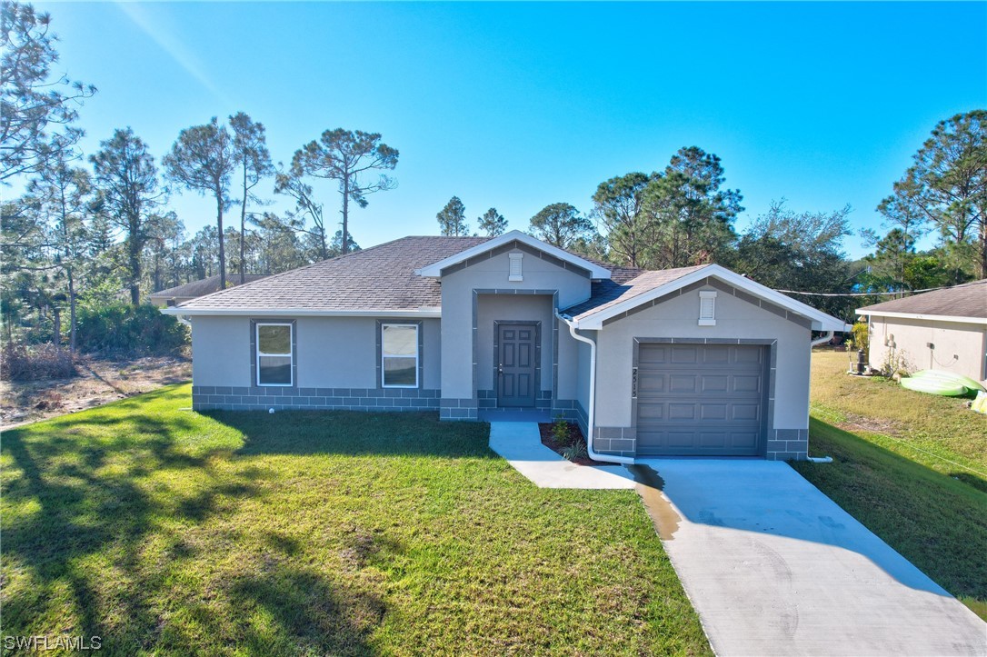 3215 46th Street West Lehigh Acres, FL 33971 - Photo 32 of 50 a view of a yard in front of a house with large windows