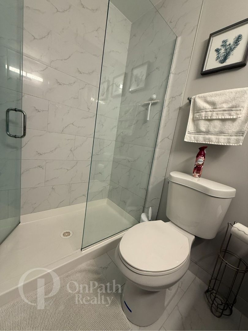 6834 West 65th Street, Unit 1 Chicago, IL 60638 - Photo 13 of 20 a white toilet sitting next to a bath tub and a shower