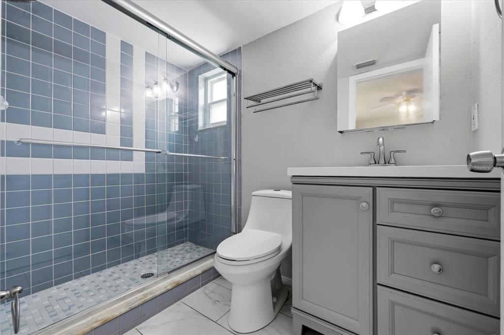 12836 Pineway Drive Largo, FL 33773 - Photo 12 of 28 a bathroom with a sink a toilet and shower