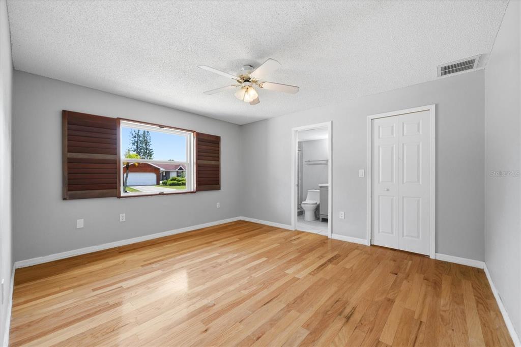 12836 Pineway Drive Largo, FL 33773 - Photo 13 of 28 a view of empty room with wooden floor and fan