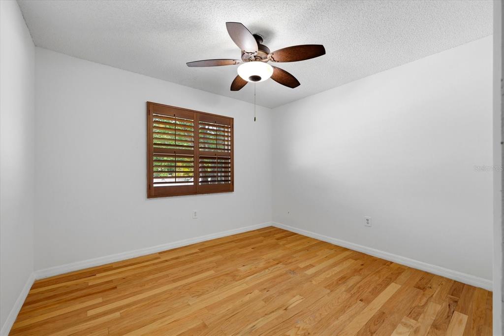 12836 Pineway Drive Largo, FL 33773 - Photo 16 of 28 a view of an empty room with wooden floor