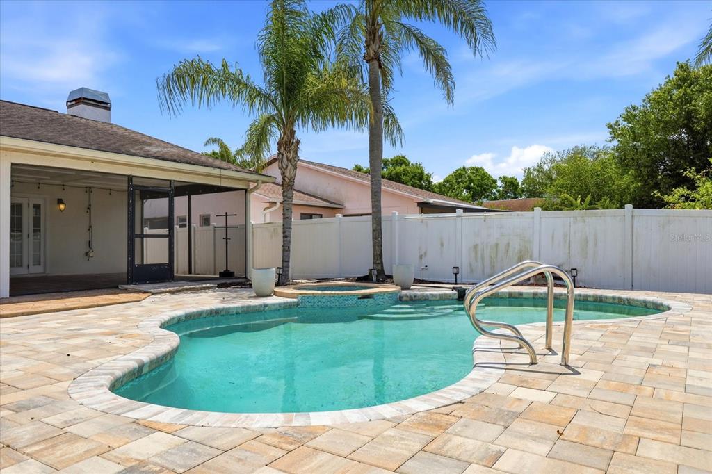 12836 Pineway Drive Largo, FL 33773 - Photo 22 of 28 a view of a backyard with a barbeque and palm trees