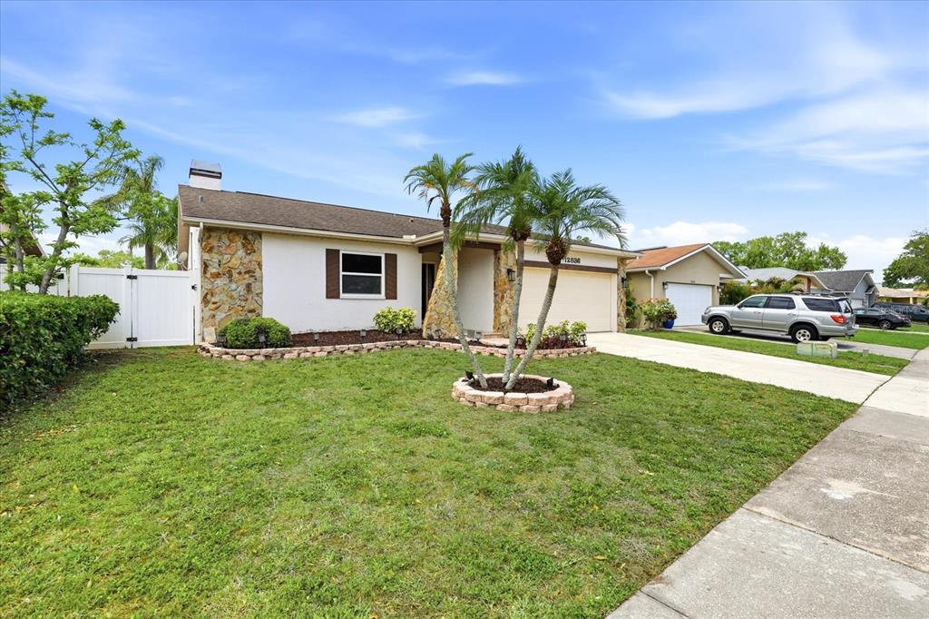12836 Pineway Drive Largo, FL 33773 - Photo 28 of 28 a front view of house with yard and outdoor seating