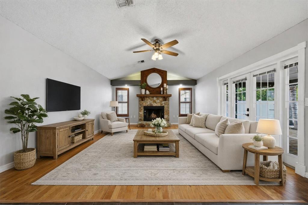 12836 Pineway Drive Largo, FL 33773 - Photo 3 of 28 a living room with furniture a fireplace and a flat screen tv