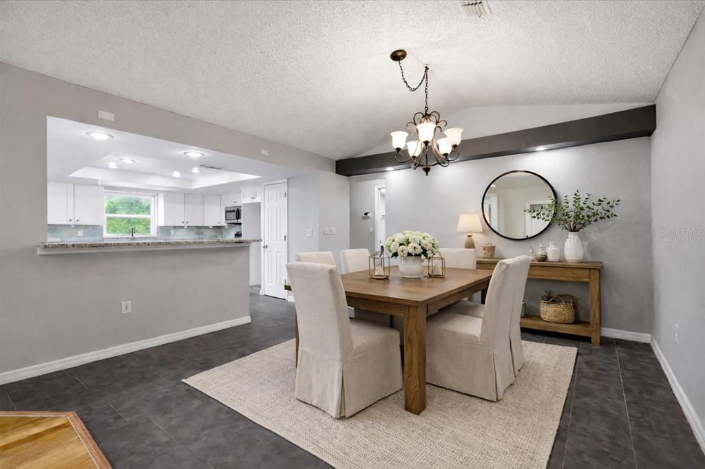 12836 Pineway Drive Largo, FL 33773 - Photo 5 of 28 a kitchen with a table and a chandelier