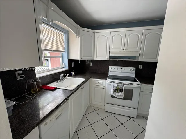 a kitchen with cabinets appliances and a window