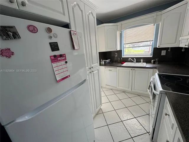 a kitchen with stainless steel appliances a sink a stove a refrigerator and cabinets