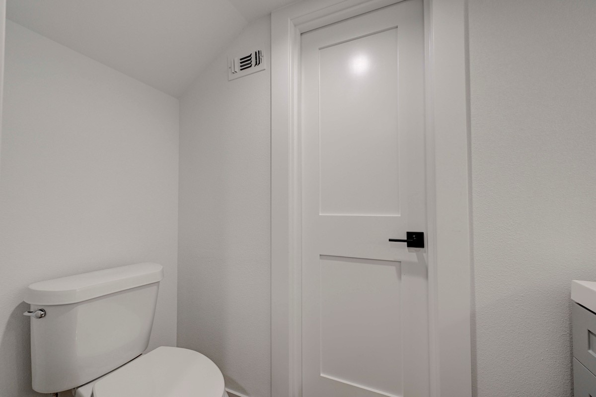 2220 Yellow Jacket Lane, Unit 1 Austin, TX 78741 - Photo 16 of 35 A well-appointed lavatory featuring a contemporary door with sleek hardware and crisp, white finishes.