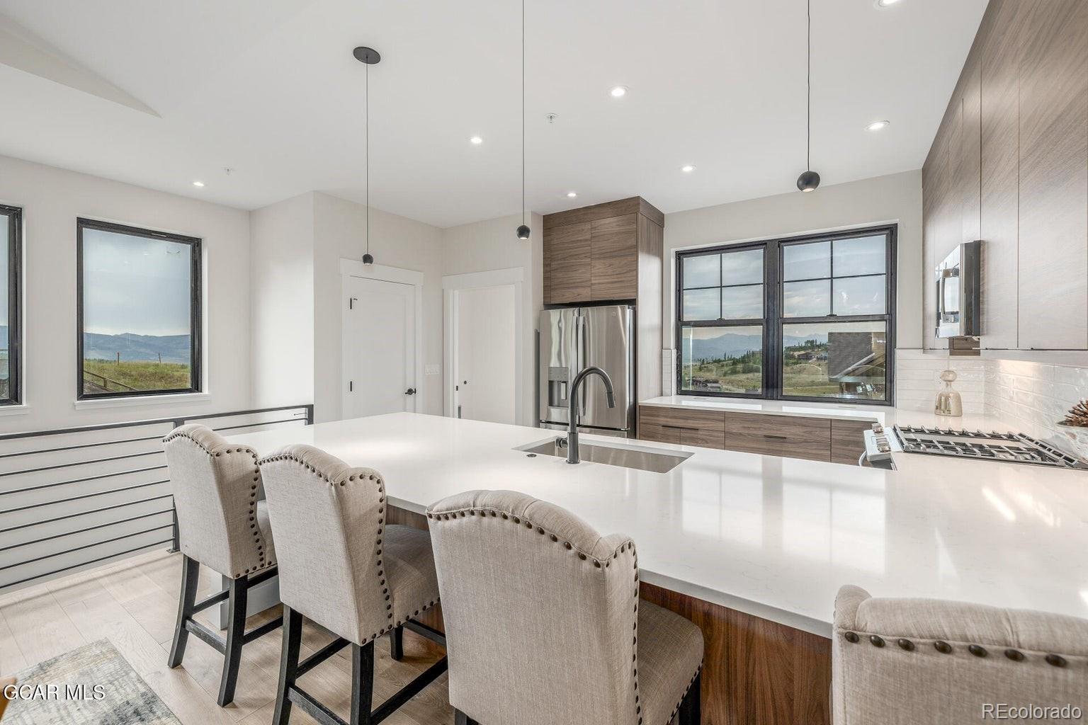 104 Saddle Mountain Camp Road Granby, CO 80446 - Photo 17 of 50 a kitchen with stainless steel appliances granite countertop a sink a stove and a wooden cabinets
