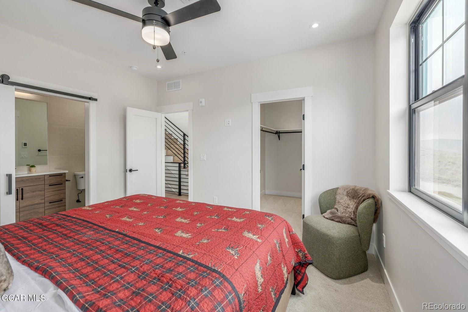 104 Saddle Mountain Camp Road Granby, CO 80446 - Photo 25 of 50 a bedroom with a bed and a chandelier