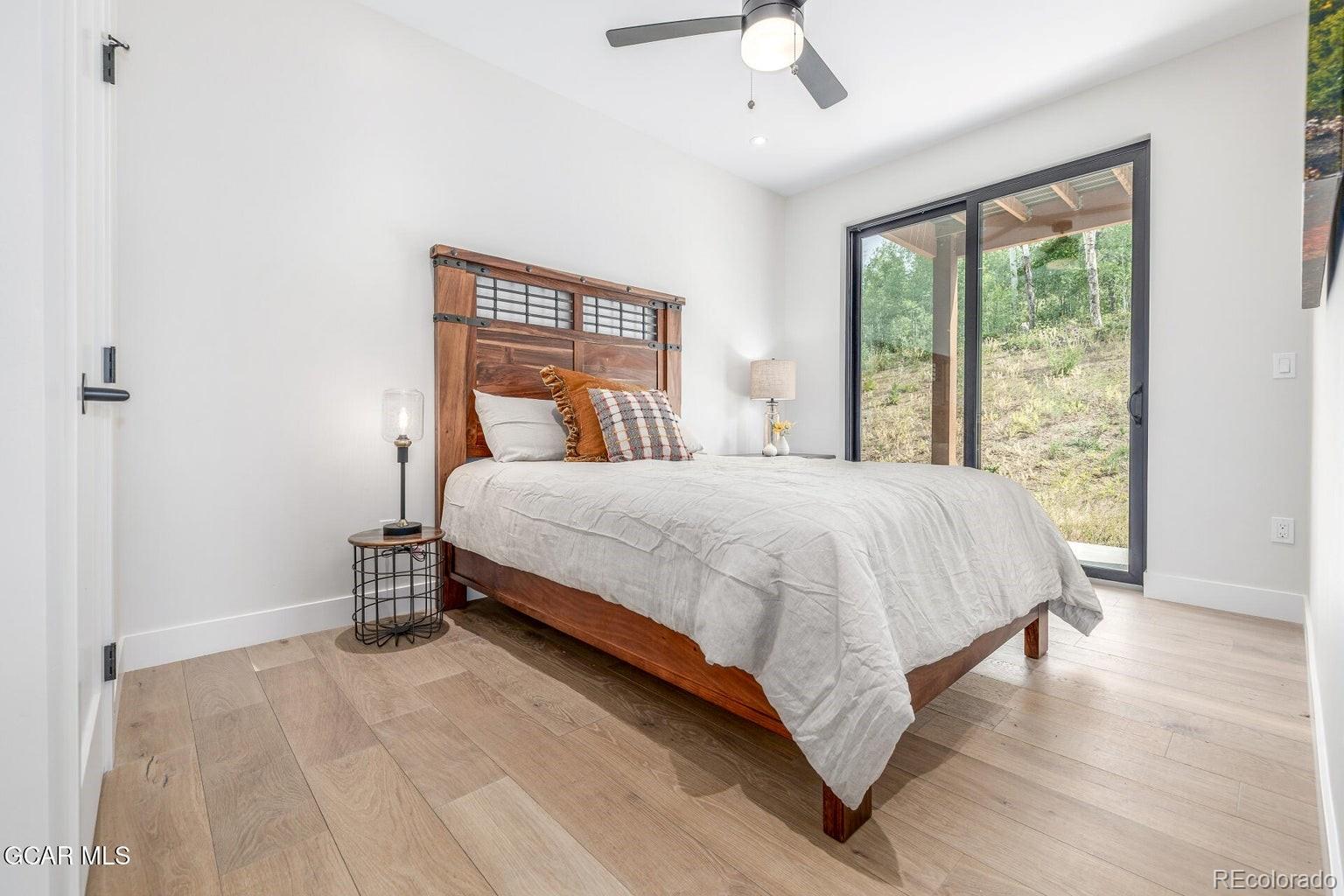 104 Saddle Mountain Camp Road Granby, CO 80446 - Photo 35 of 50 a bedroom with a large bed and a large window