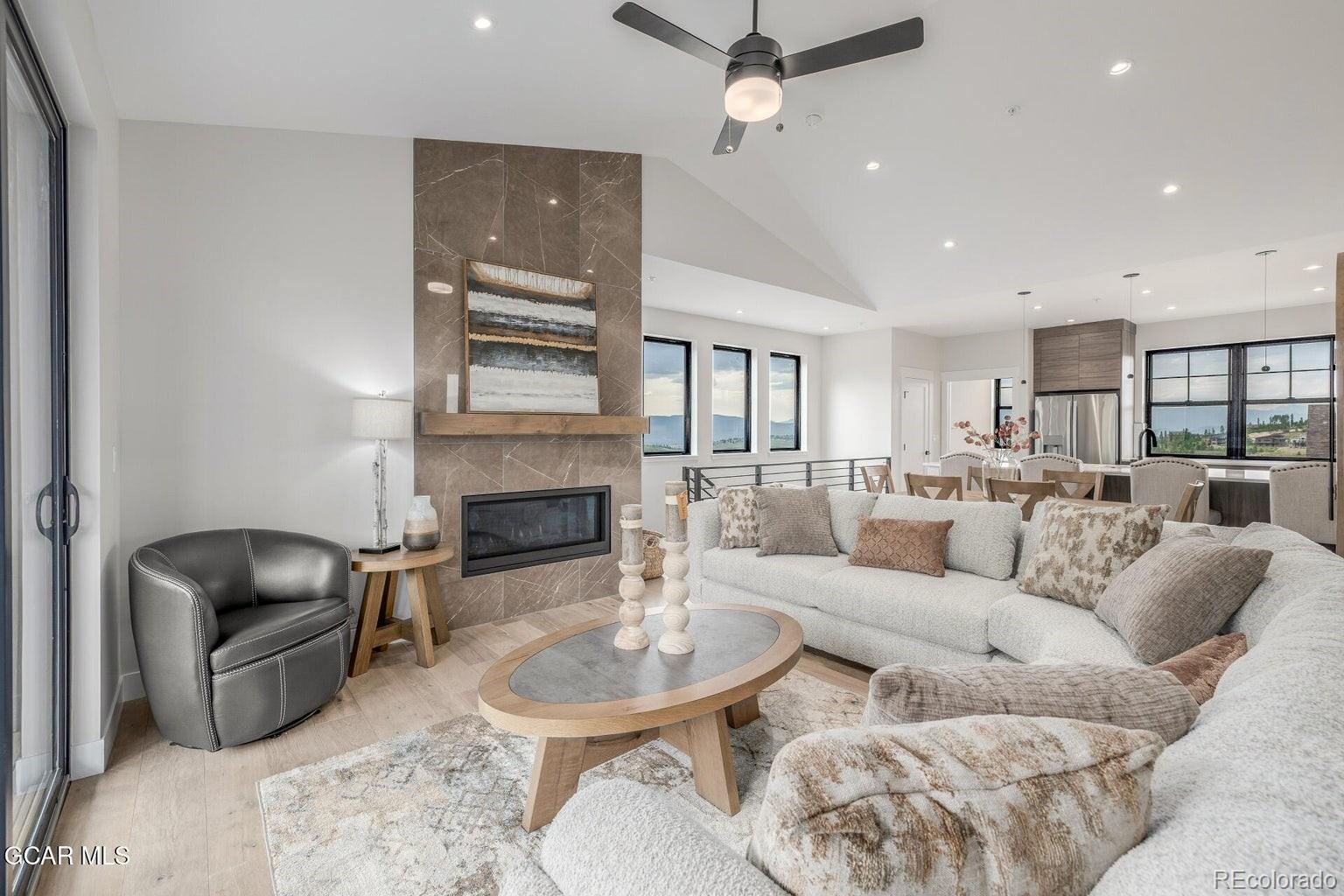 104 Saddle Mountain Camp Road Granby, CO 80446 - Photo 4 of 50 a living room with furniture a fireplace and a chandelier