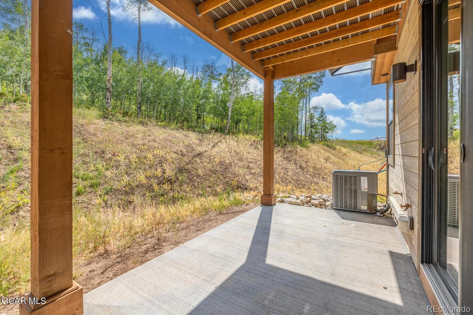 104 Saddle Mountain Camp Road Granby, CO 80446 - Photo 49 of 50 a view of a porch with a floor to ceiling window next to a yard