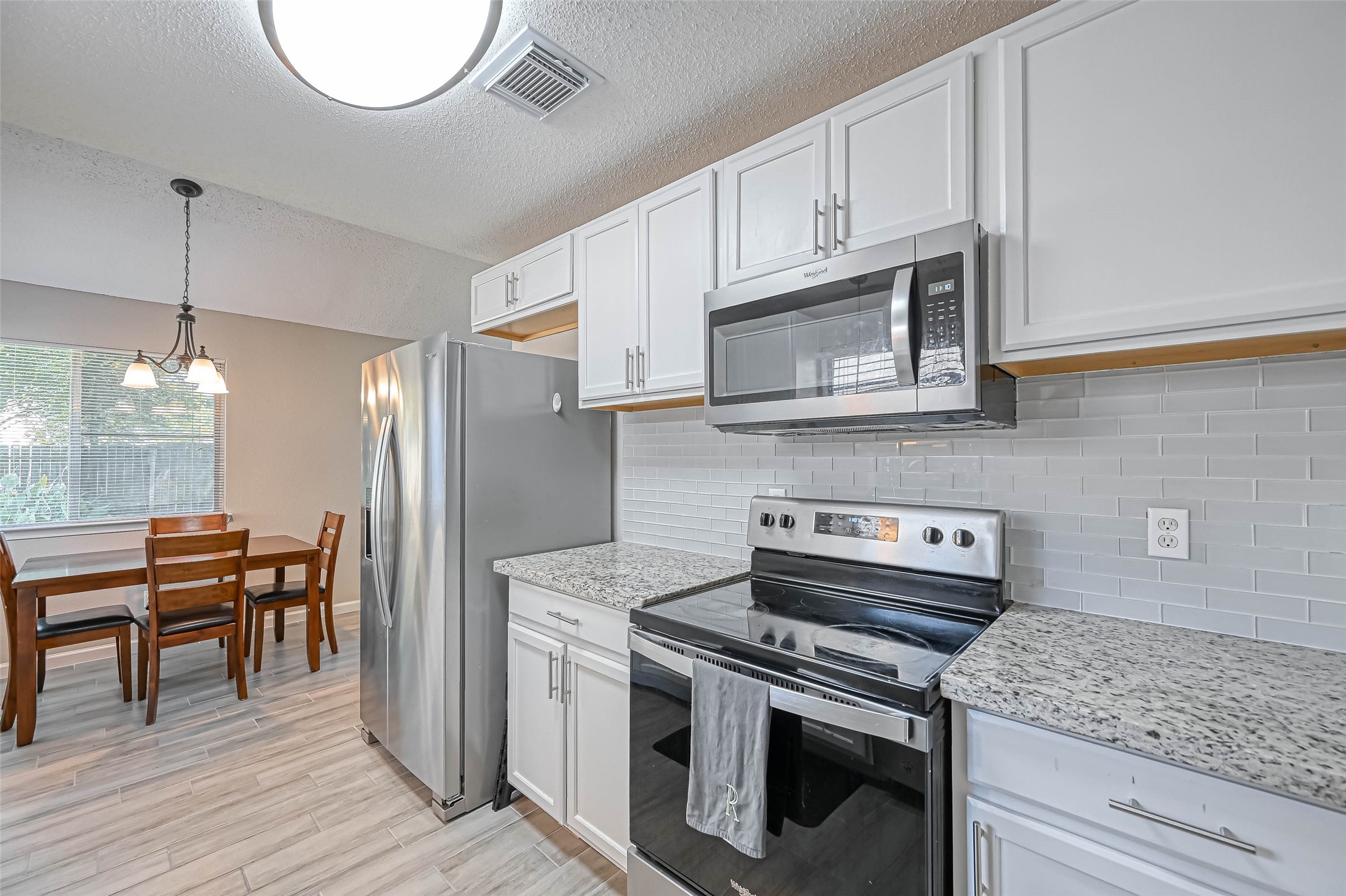 22622 John Rolfe Lane Katy, TX 77449 - Photo 9 of 21 a kitchen with stainless steel appliances granite countertop a stove microwave and cabinets