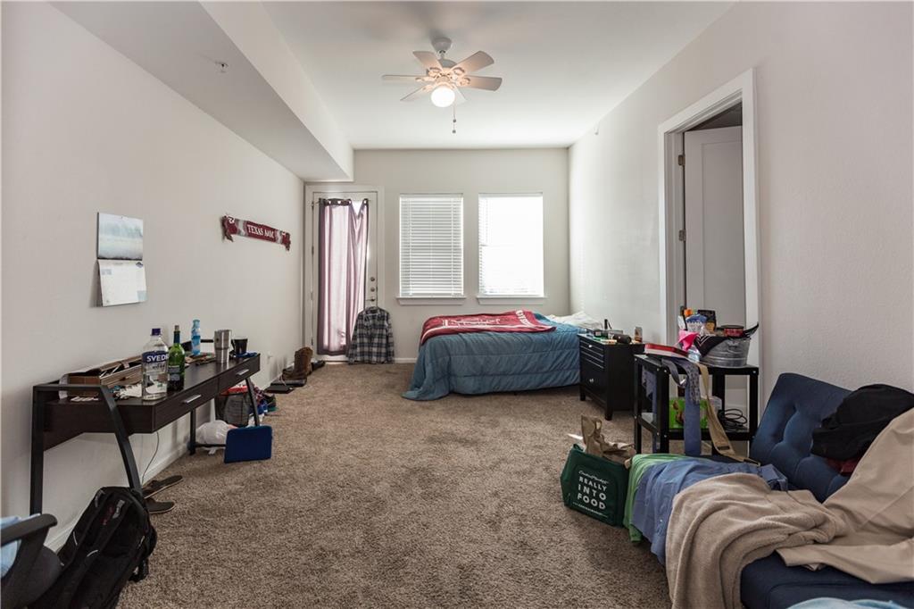 2708 San Pedro Street, Unit 302 Austin, TX 78705 - Photo 4 of 11 a bedroom with furniture a bed and a chandelier