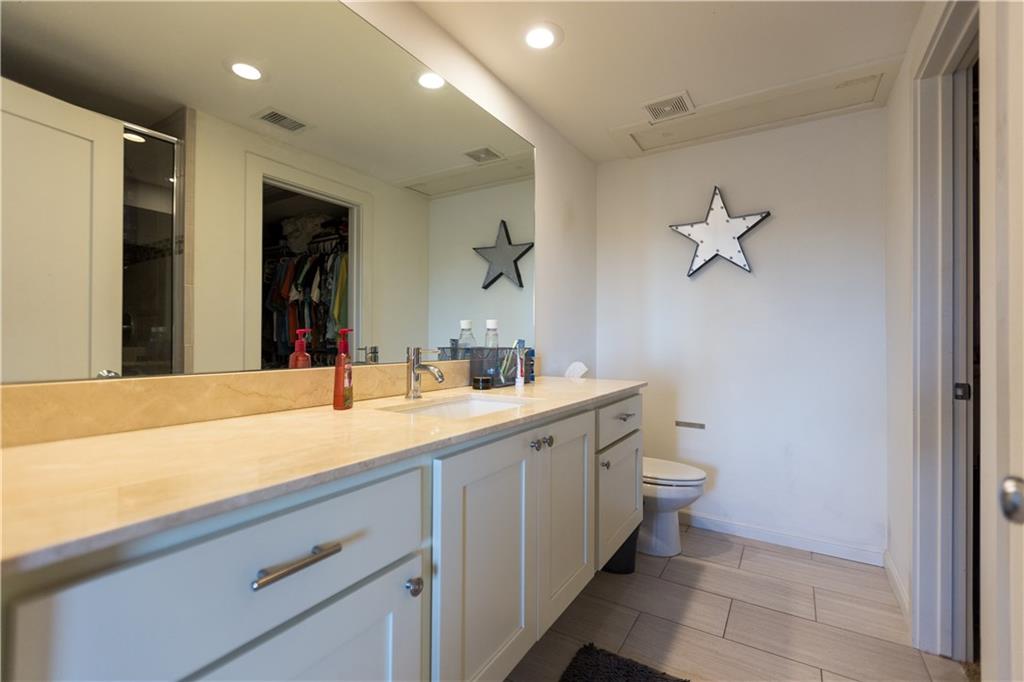 2708 San Pedro Street, Unit 302 Austin, TX 78705 - Photo 6 of 11 a bathroom with a sink a toilet and a mirror