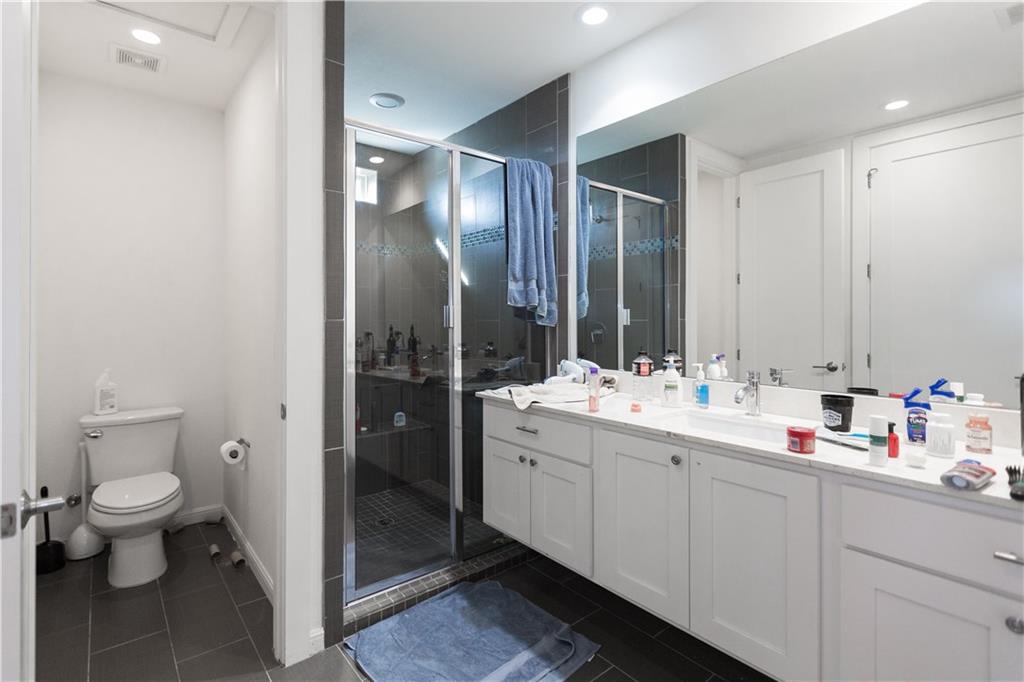 2708 San Pedro Street, Unit 302 Austin, TX 78705 - Photo 7 of 11 a bathroom with a double vanity sink mirror and toilet