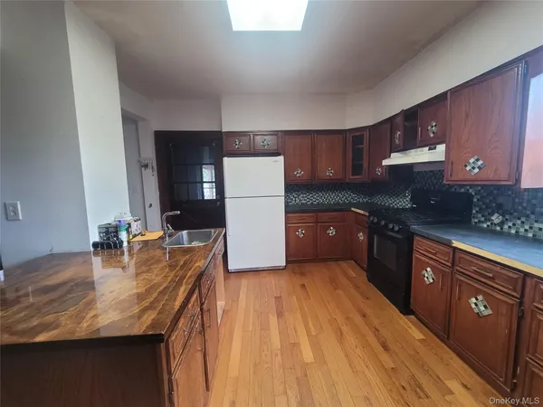 a kitchen with granite countertop a sink stove and cabinets