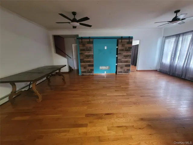 a view of an empty room with a window and a ceiling fan